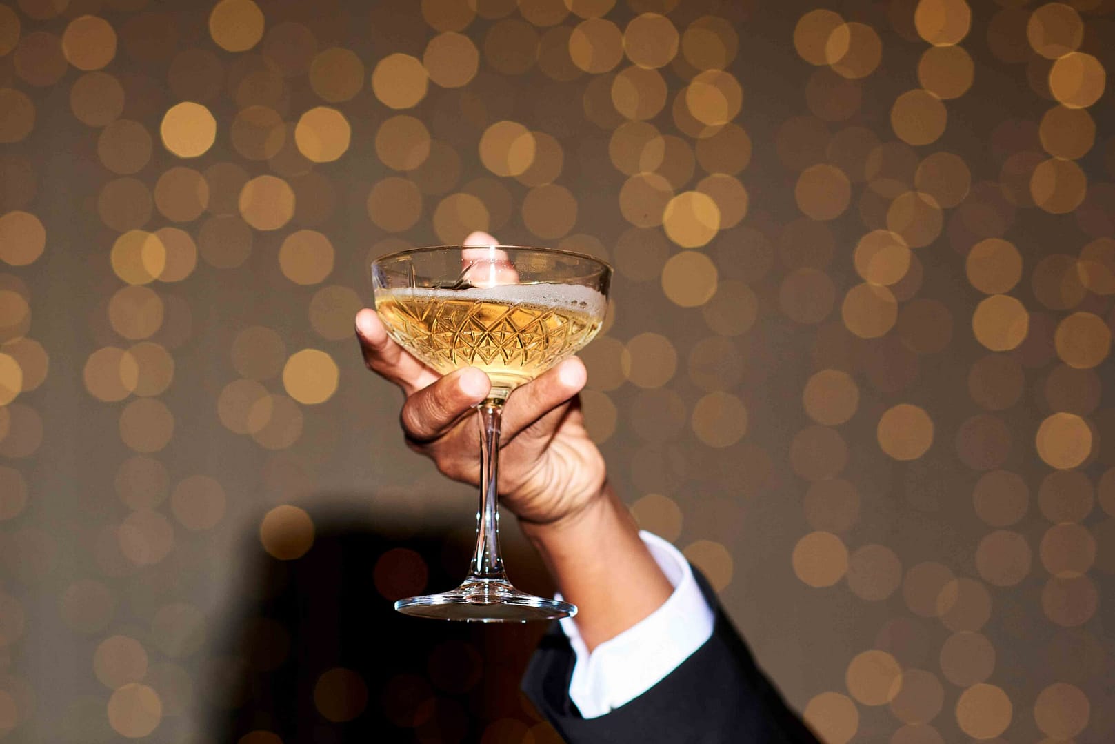 celebratory champagne held in a hand during a charity ball