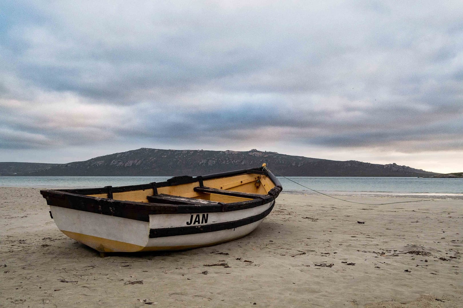 Film shot of a fishing boat under a cloudy sky at the Langebaan beachfront in South Africa. Photographer Stefan Venter.