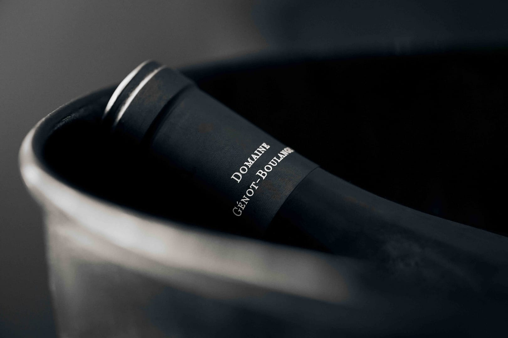 Black and white Macro image of french bottle of wine in an ice bucket at a Rueda Wine Consulting exclusive event hosted at Noop Restaurant in Paarl, Cape Town. Stefan Venter Photography.