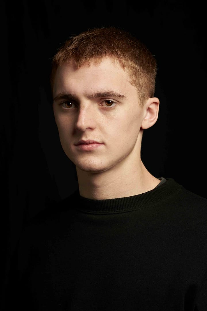 Male model with brown eyes in moody beauty portrait with serious expression. Shot in studio by Stefan Venter Photography in Cape Town, South Africa.