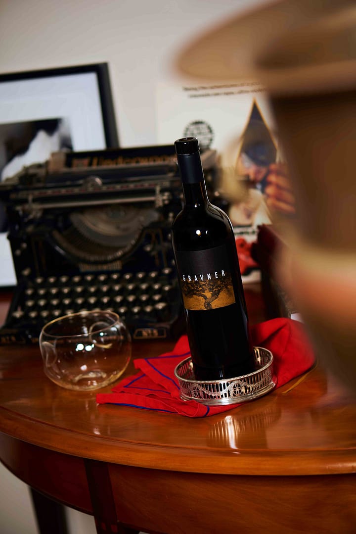 Artsy and conceptually styled picture of a premium Gravner orange wine. Stefan Venter photography of wine bottle with typewriter. Orange Wine. Product photographer Cape Town - Stefan Venter