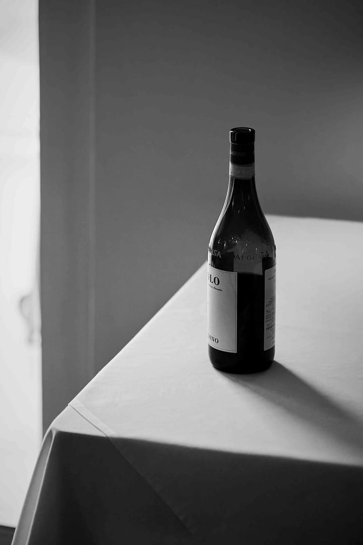 Black and white silhouette of an empty Barolo bottle on a white table. Noop, Paarl. Stefan Venter Photography. Event.